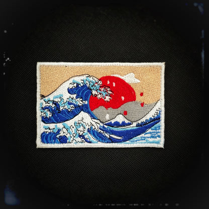 Woven patch with velcro: Kanagawa wave (1831) The iconic Kanagawa Wave is a beautiful tribute to one of Japan’s most famous and timeless artworks. The Great Wave off Kanagawa, is a masterpiece by the renowned Japanese artist Hokusai. This design captures the dramatic power of the ocean, with a towering wave cresting over tiny boats, symbolizing both nature’s strength and beauty. High quality and durable PVC patch for collectors, airsofters and members of the military. Patchworld. patchworld.net