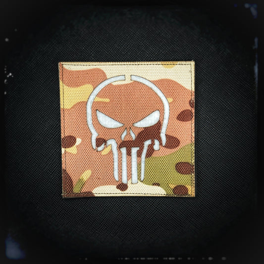 Reflective patch with velcro: Punisher Skull. The reflective laser-cut Multicam patch featuring the iconic Punisher skull, a symbol that originates from Marvel Comics. This symbol has become synonymous with toughness, grit, and a no-nonsense attitude, making it a favorite among military personnel, law enforcement, and fans of the character. High quality and durable PVC patch for collectors, airsofters and members of the military. Also serves as a morale patch. Patchworld. patchworld.net