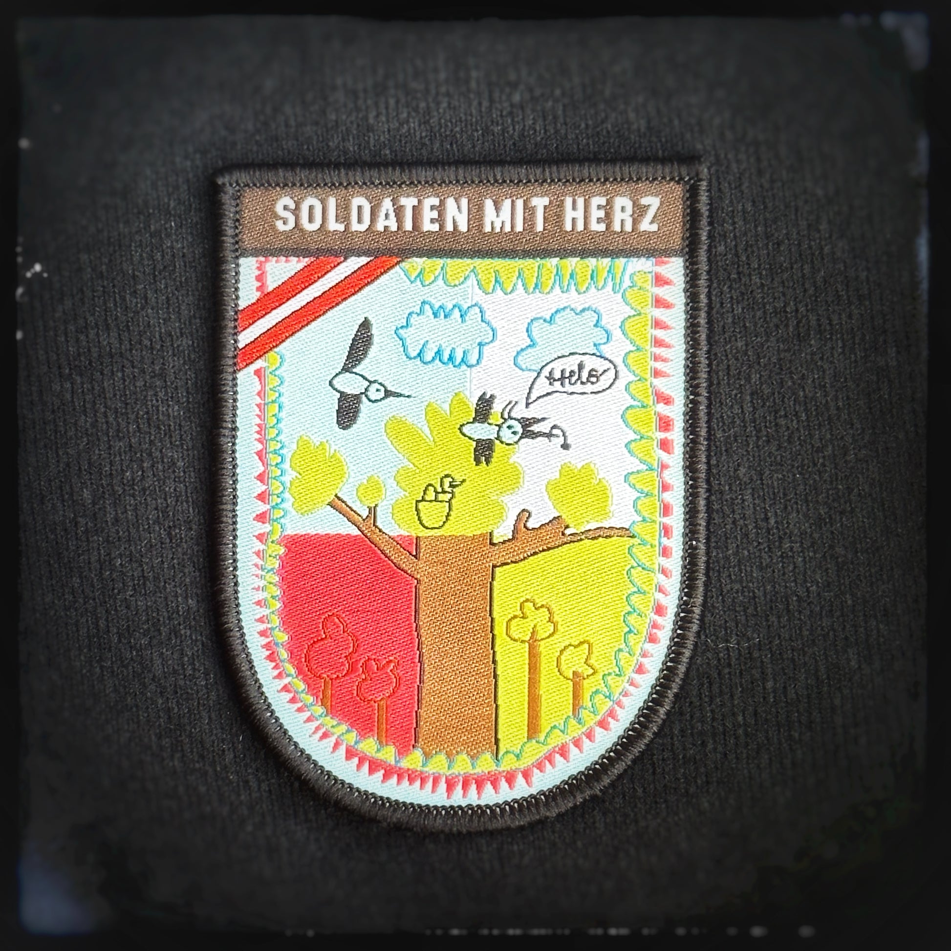 Gewebter Patch mit Klett: Malwettbewerb 2023, Damien (8). Mit den Kauf des Patches ünterstützt du den wohltätigen Verein.Diese tollen Patches wurden von Kindern im Rahmen eines Malwettbewerbs gestaltet!Mit dem Kauf eines Patches helfen Sie direkt Kindern und Jugendlichen in Not. Alle Spenden gehen direkt an die Hilfsorganisation Soldaten mit Herz, welche Kinderwünsche erfüllen lässt.